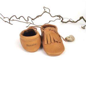 Krabbelschuhe aus pflanzlich gegerbtem Leder – handgemachte Babypuschen in Cognacbraun mit Fransen.