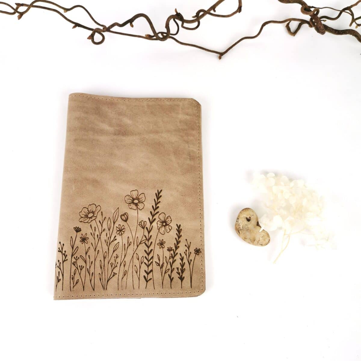 Handgemachte U-Heft-Hülle aus naturgegerbtem Leder mit floraler Gravur.