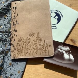 Mutterpasshülle aus pflanzlich gegerbtem Leder mit Blumengravur – handgemacht und nachhaltig.