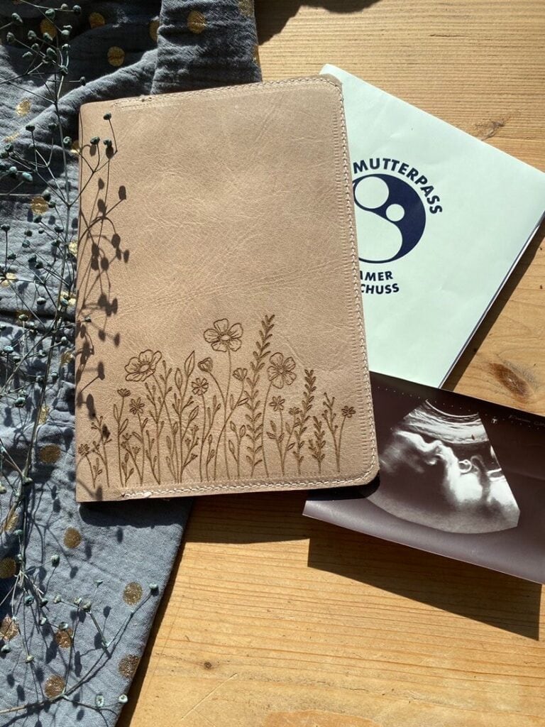 Mutterpasshülle aus pflanzlich gegerbtem Leder mit Blumengravur – handgemacht und nachhaltig.